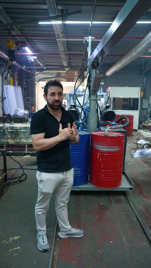 The server explains the combustion process with hand movements in front of a production machine.