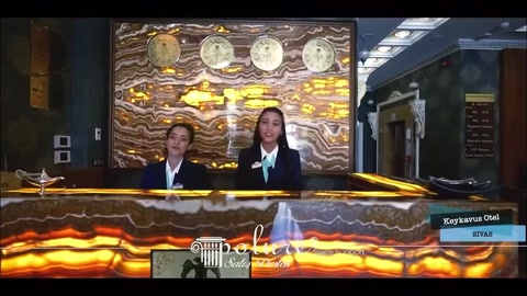 Bancone della reception con motivo ondulato davanti a un pannello murale in rilievo