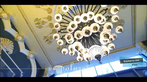 Soffitto scenografico della hall incorniciato da un rosone centrale e modanature decorative