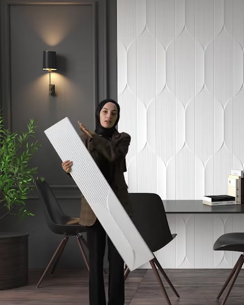 A decorative wall panel is held diagonally to showcase its surface texture
