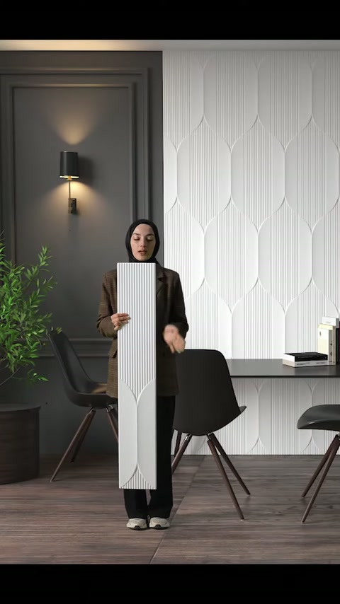 Il presentatore mostra un pannello murale in poliuretano bianco goffrato in un ufficio moderno posizionato verticalmente.