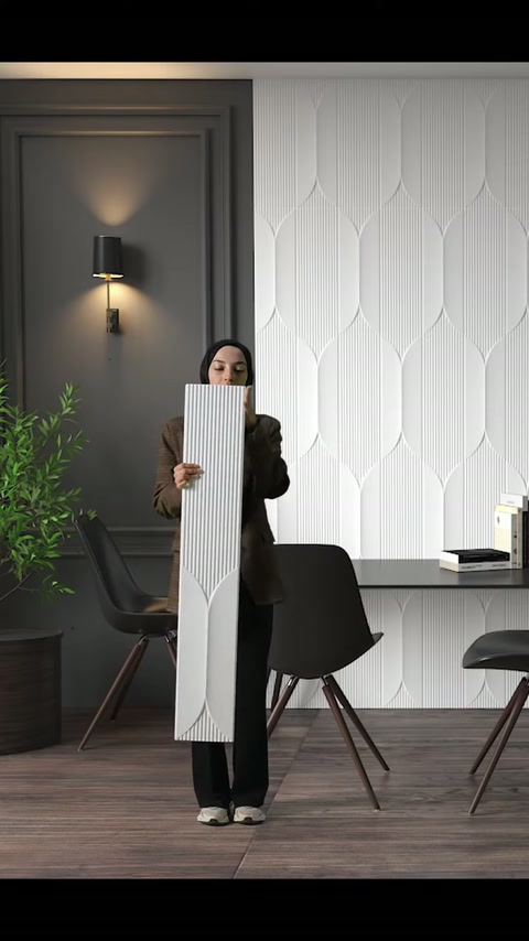 Il lungo pannello murale viene tenuto con entrambe le mani per evidenziare la texture superficiale.