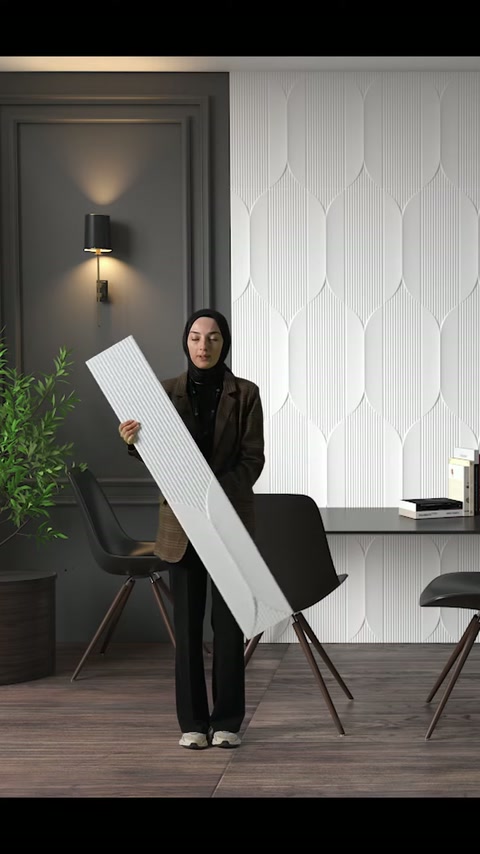 I dettagli della superficie geometrica rimangono visibili mentre il pannello in poliuretano bianco viene tenuto diagonalmente.