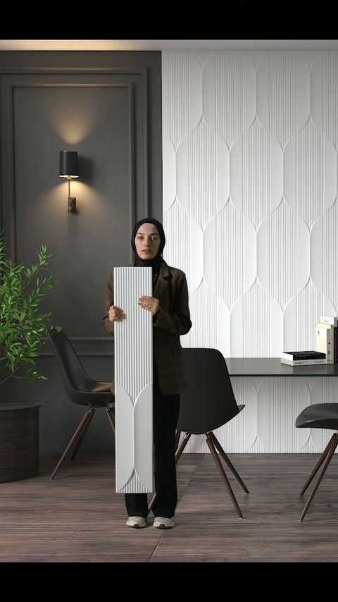 Il presentatore indica con la mano la texture finemente rigata sul pannello verticale in poliuretano.