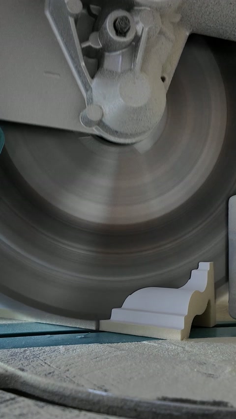 CNC cutter shapes a decorative profile from white moulding material