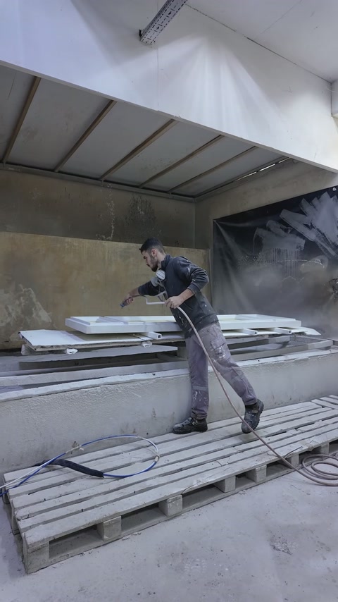 Workshop finishing area shows decorative panels prepared for spray coating