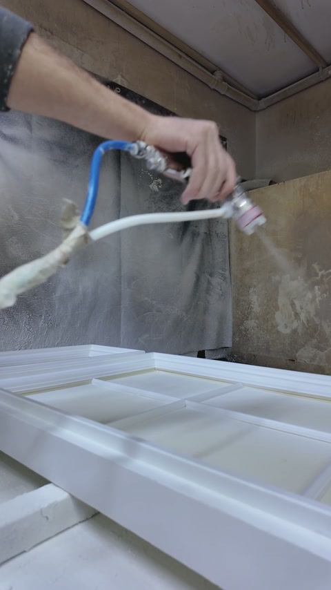 Spray coating is applied evenly across the raised panel mouldings