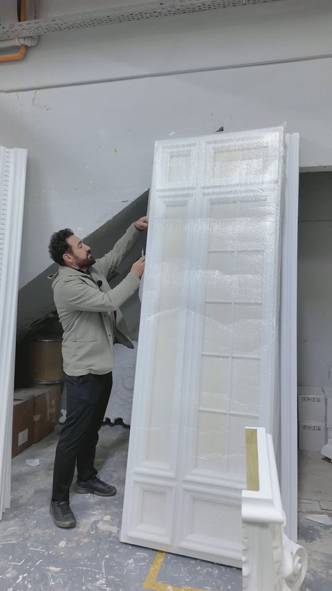 Tall wrapped decorative panel is positioned upright inside the workshop