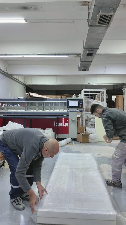 Workers secure protective material around the finished decorative panel
