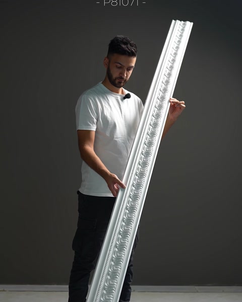 Una cornice stretta e ornata mostra dettagli decorativi in rilievo ripetuti.