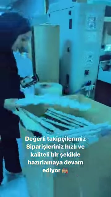 Long white decorative parts on the workbench are inspected by an employee.