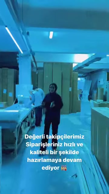 A worker showcases products while walking through the mold-lined workshop passage.