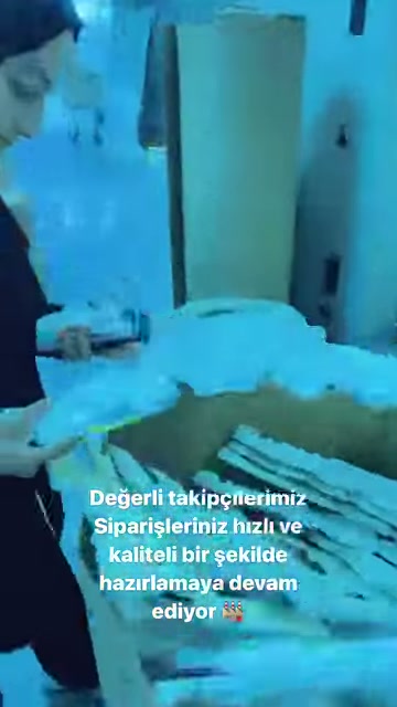A worker examines curved polyurethane ornamental pieces next to the table.