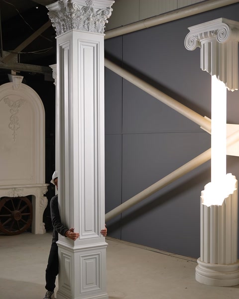 Operaio in piedi accanto a una colonna in poliuretano vicino a un elemento decorativo per camino