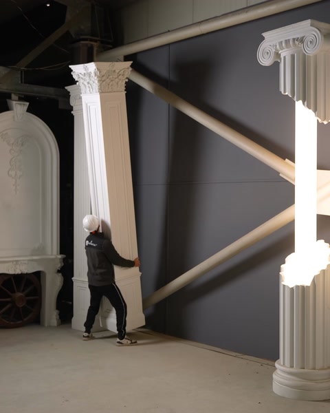 Operaio che solleva un grande pannello di colonna in poliuretano durante l'installazione