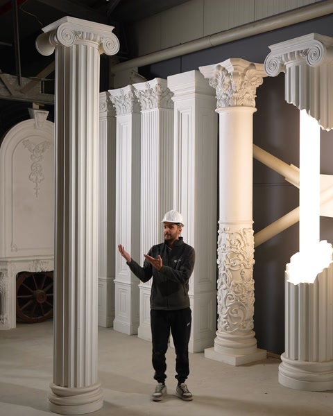 Artigiano in piedi accanto a una colonna decorativa in poliuretano con dettaglio del capitello floreale