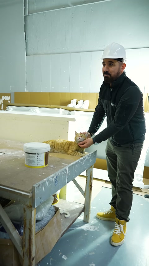 Il responsabile spiega il processo di produzione decorativa davanti al banco di lavoro dell'officina.