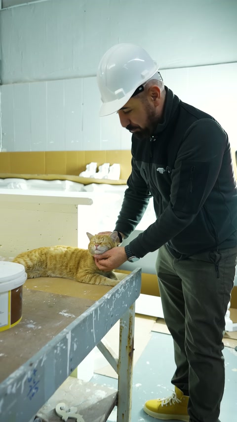 Un dipendente ispeziona da vicino i materiali sul banco di produzione.