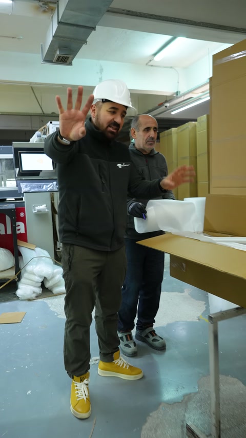 I dipendenti continuano l'imballaggio con scatole aperte e protezioni di cartone.