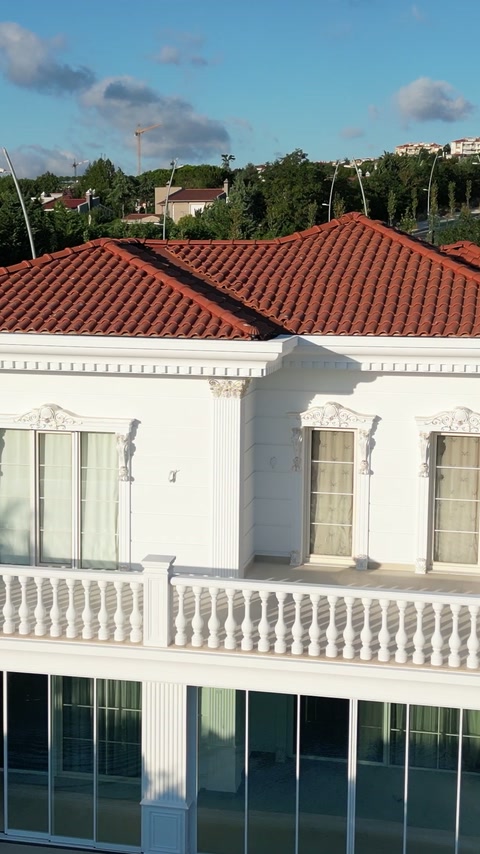 Classical white villa facade with balustrades and decorative window surrounds