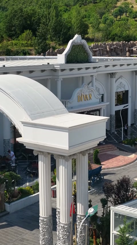 Curved entrance canopy combines cornices, columns, and decorative roof details