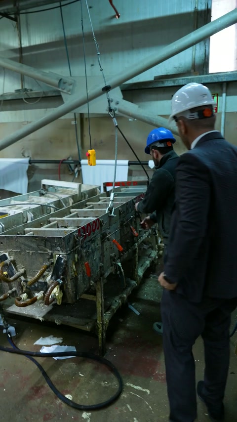 Production workers operate machinery along a polyurethane moulding line