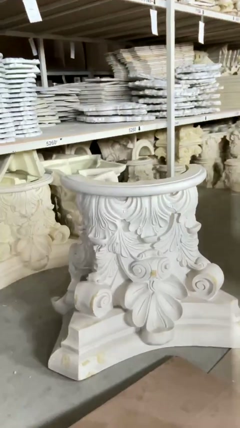 Finished decorative capitals are organized on workshop storage shelves