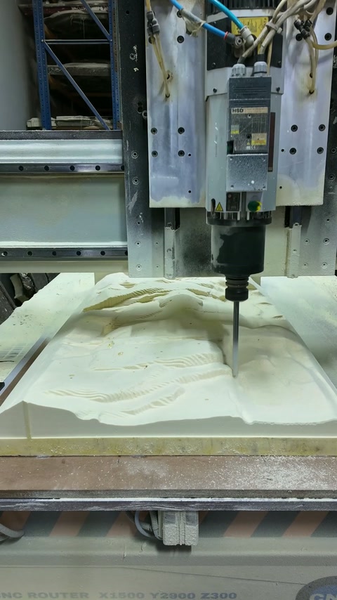 CNC machine carves an intricate floral relief into a production panel