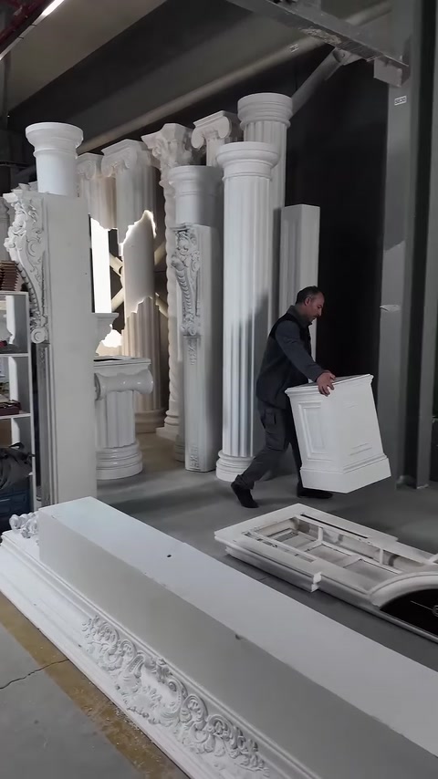 Un addetto trasporta nell'area di installazione l'elemento di base quadrato della colonna decorativa.