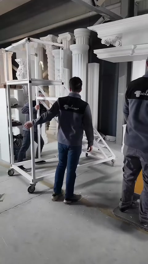 Una scala da lavoro su ruote viene portata sotto l'alta corona della porta.