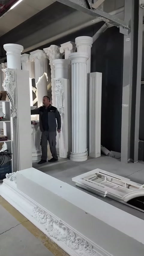 Master examines the installation area near displayed fluted columns.