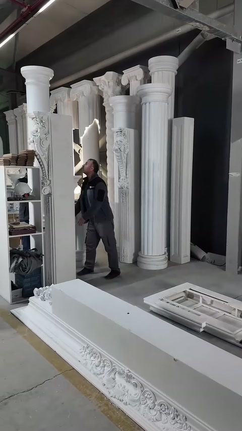 Column series positioned in front of cornice pieces on workshop floor.