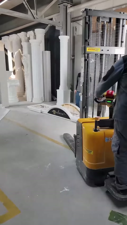 Operator brings the lifting machine close to the white columns.
