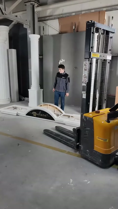 Yellow lifting machine is positioned appropriately between cornice pieces.