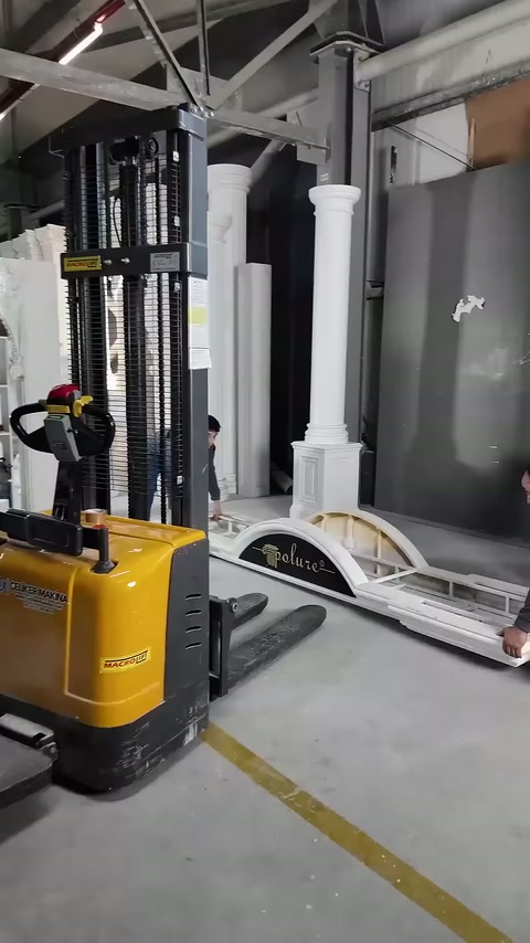 Lifting machine forks wait beside decorative pieces on the ground.