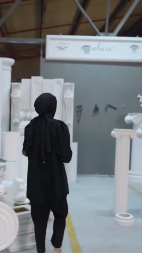 Il presentatore cammina verso la sezione con colonne decorative bianche