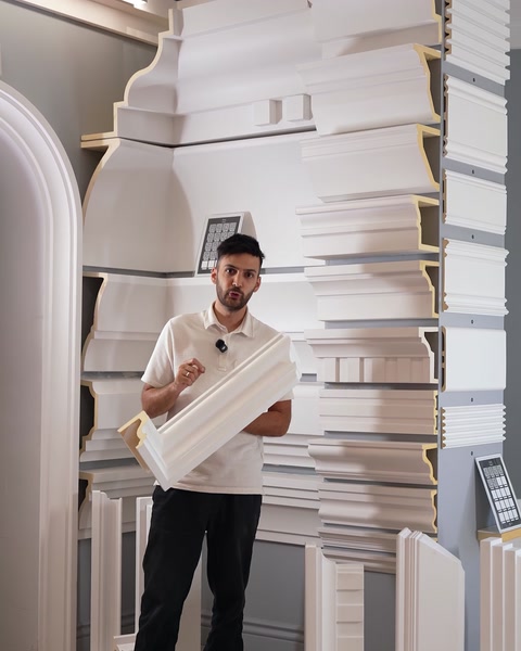 Man holding curved polyurethane cornice moulding sample piece.