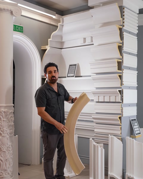 Man holding large curved arch polyurethane moulding piece.
