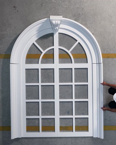 Arched window frame with polyurethane surround and grid panes.