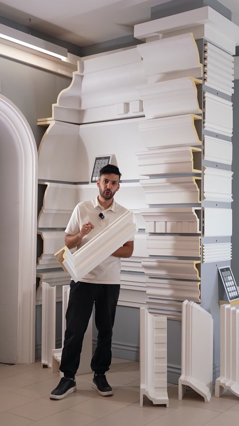 Man holding curved polyurethane cornice moulding sample piece.