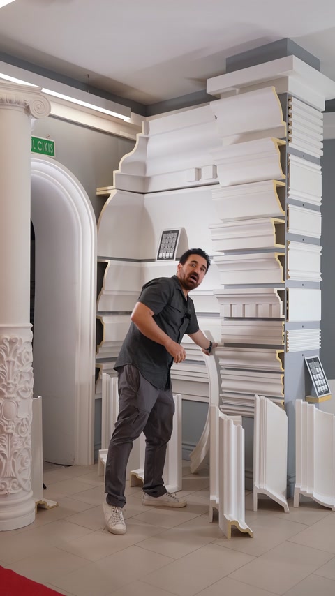 Man bending flexible curved polyurethane moulding profile by hand.