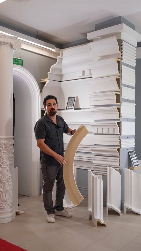 Man holding large curved arch polyurethane moulding piece.