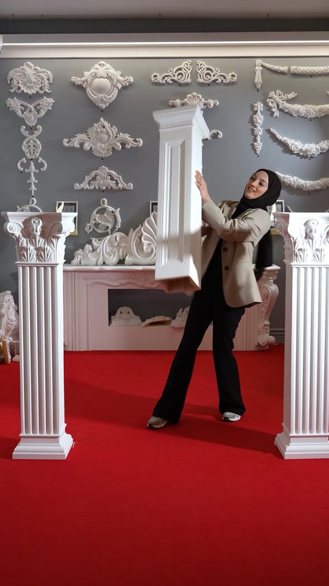Woman holding a tall polyurethane pedestal column upright