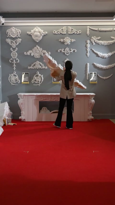 The video shows a presenter indicating polyurethane ornaments in a showroom.