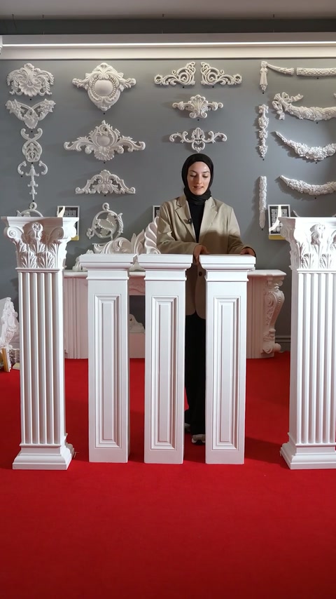 Completed pedestal columns with ornate capitals are compared in the showroom.