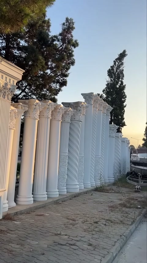 Corinthian-topped white column models standing side by side in evening light