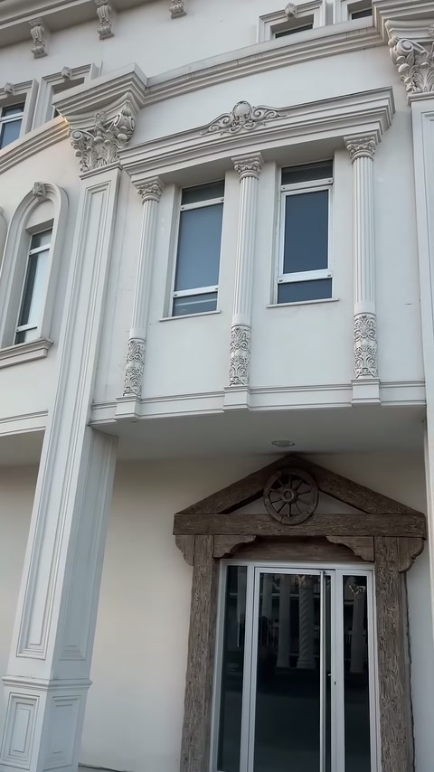 Balcony section with embossed shafts and Corinthian capitals completing the facade