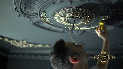 Curved details of the round ceiling medallion are highlighted with gold-effect paint