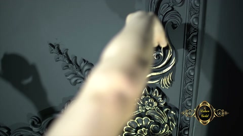 Il pennello aggiunge tocchi dorati alle sezioni rilievo della decorazione da soffitto