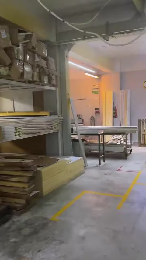 Stacked polyurethane profiles and workbenches are seen in the production area.
